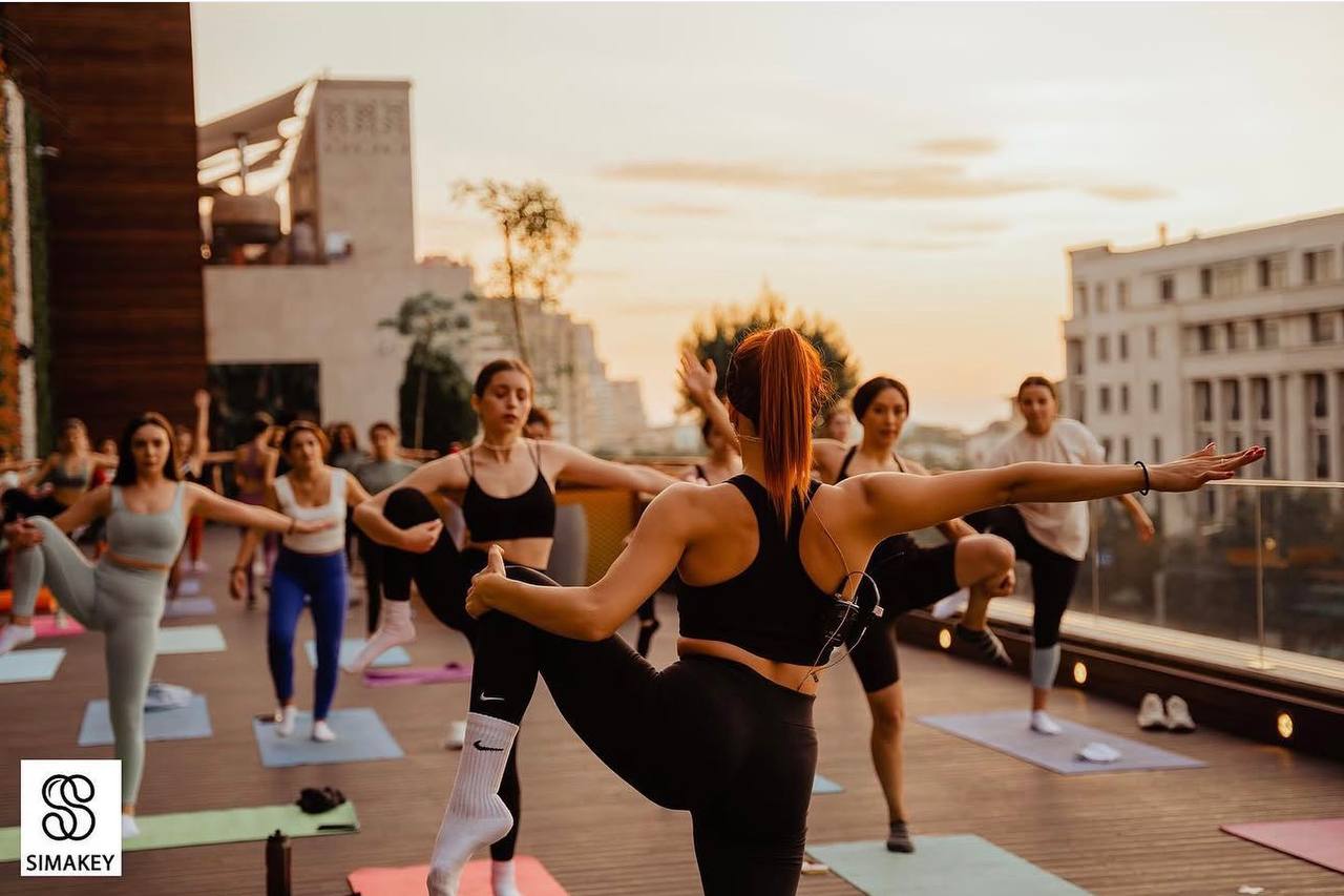 Klara leading a rooftop stretching class at sunset