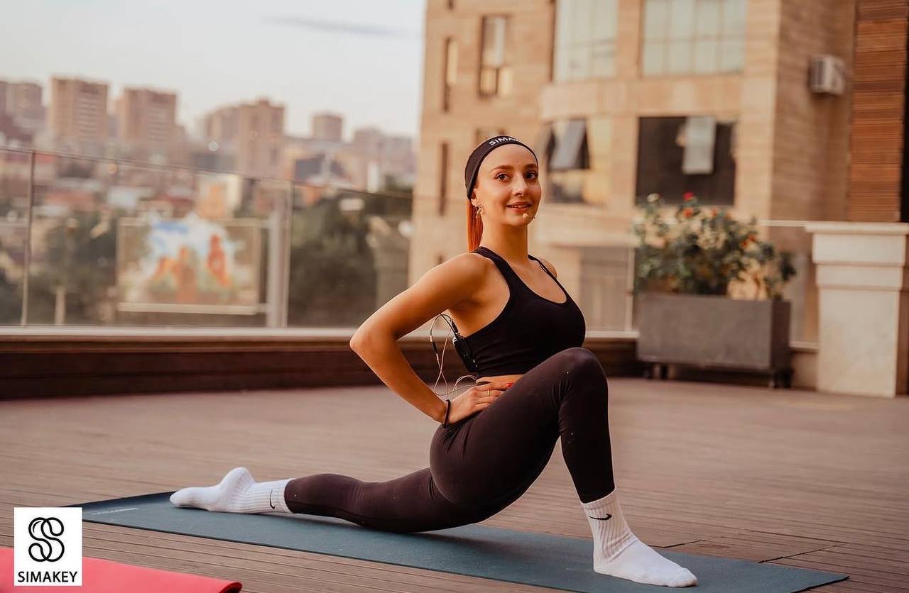 Klara Simonyan stretching on a rooftop at golden hour