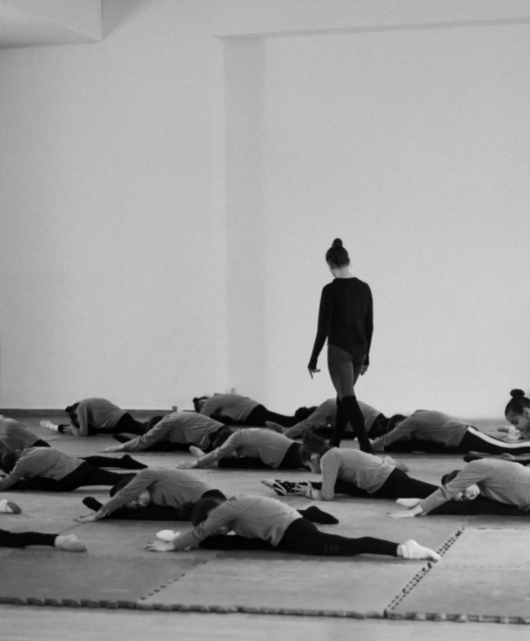 A class of children stretching together on the studio floor